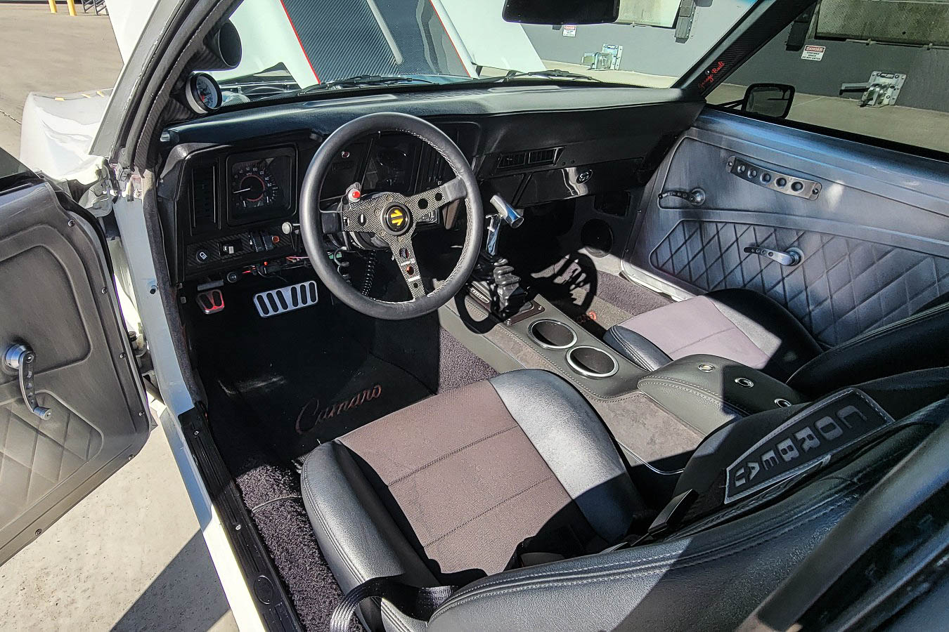 Interior shot showcasing Corbeau Sport Seats, Dakota Digital VHX gauges, and the Momo carbon fiber steering wheel.