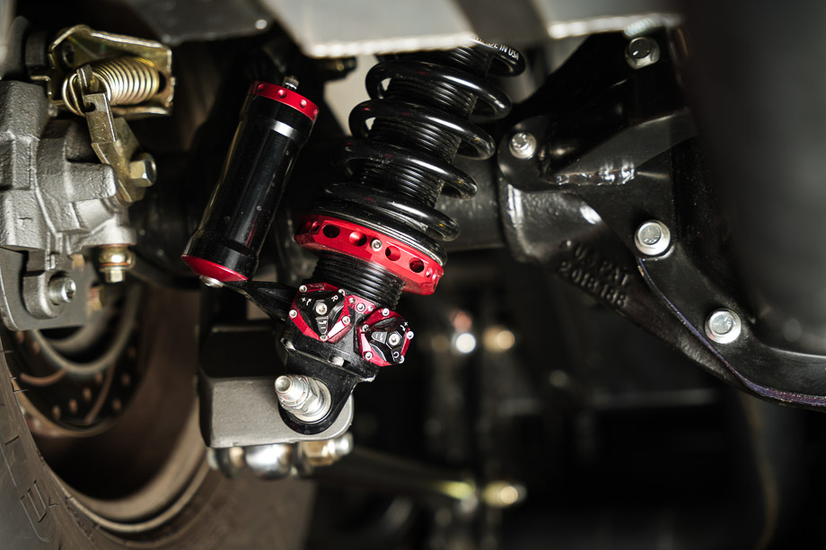 Close-up of the rear suspension on the 1956 Chevy 3100, featuring QA1 MOD shocks and a Watts link setup.